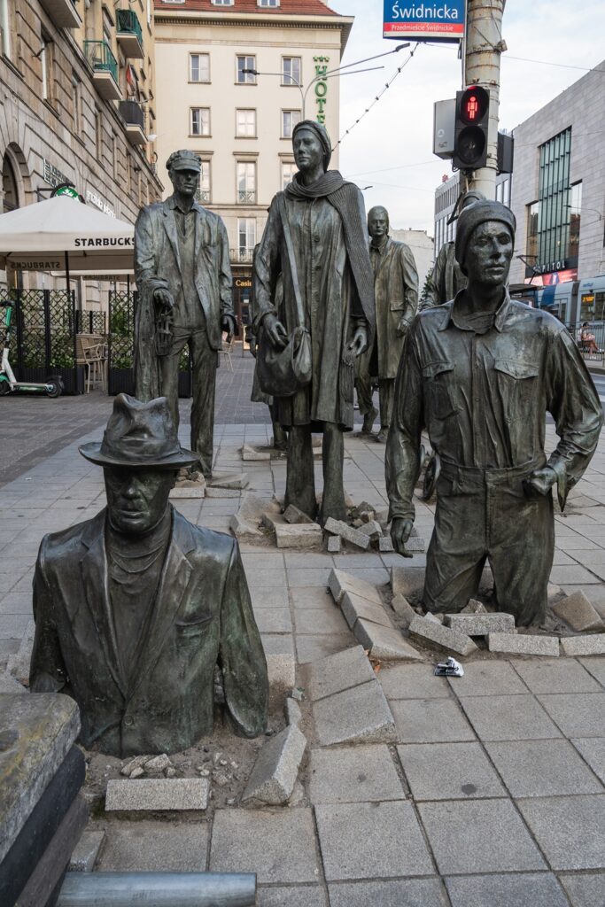 Monumento ai Passanti Breslavia figure che emergono dal terreno