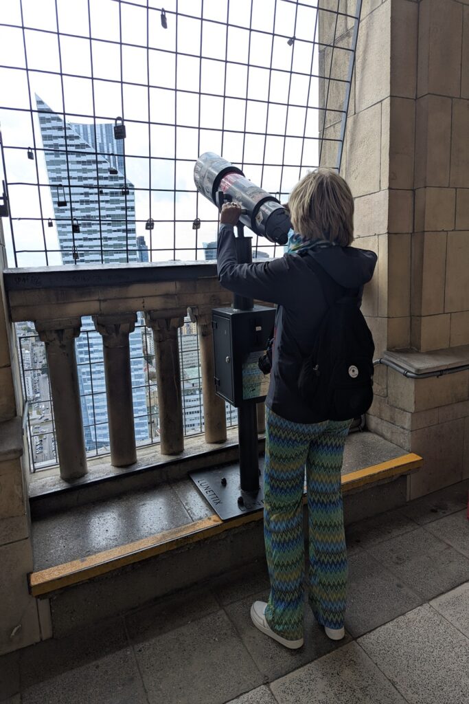 persona che osserva varsavia dalla terrazza del palazzo della cultura con cannocchiale