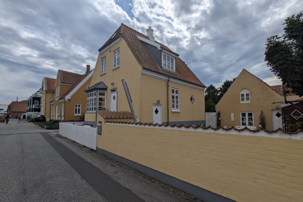 Danimarca on the Road: il viaggio che non ti aspetti 8 Fila di case tradizionali gialle con tetti in tegole rosse lungo una tranquilla strada residenziale di Skagen, nel nord della Danimarca.