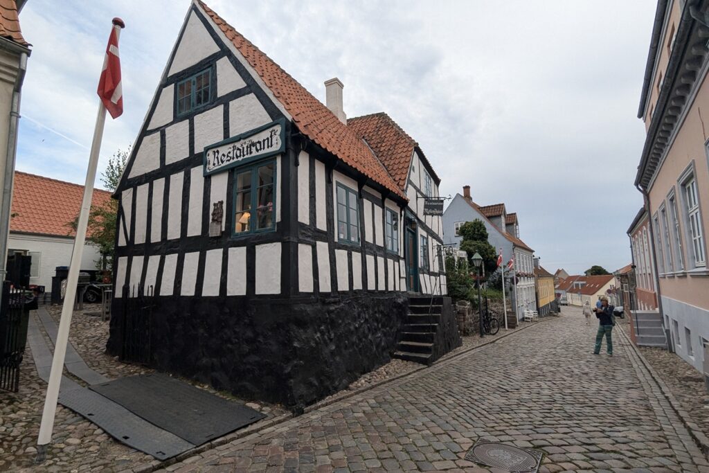 Danimarca on the Road: il viaggio che non ti aspetti 19 Una strada acciottolata del centro storico di Ebeltoft con caratteristiche case a graticcio e abitazioni tradizionali danesi.