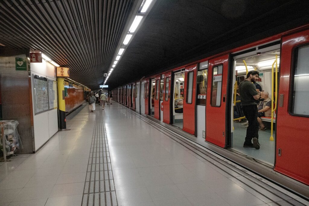 Barcellona in 6 giorni: molto più della città di Gaudí 29 Treno della metropolitana fermo in una stazione della metro di Barcellona con passeggeri in salita e discesa.