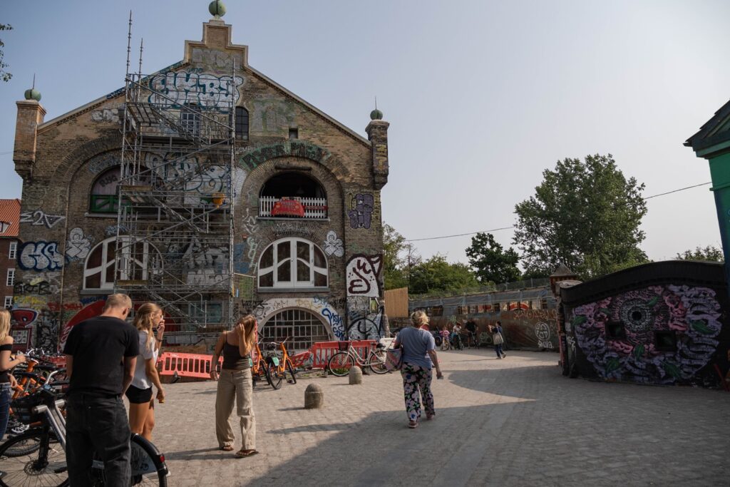 Cosa vedere a Copenaghen in 3 giorni: itinerario e consigli per visitare la capitale danese 17 Edificio ricoperto di graffiti e visitatori nel quartiere di Christiania a Copenaghen